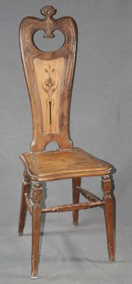 une image représentant une chaise en bois dont le dossier et l'assise sont sculptés