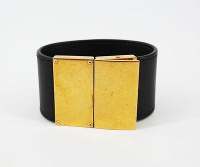 un gros plan sur un bracelet noir et doré muni d'une boucle carrée
