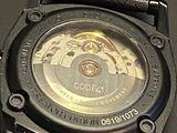 a close up of a watch on a black surface