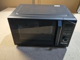 a black microwave oven sitting on a counter top