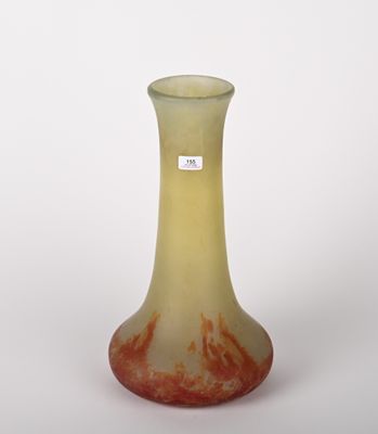 un vase jaune et rouge posé sur une surface blanche