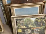 beaucoup d'œuvres d'art encadrées posées par terre dans un magasin