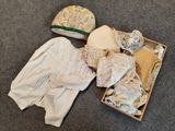 une boîte remplie de vêtements et un chapeau par terre