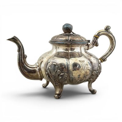 an old silver teapot with a bird on top of it