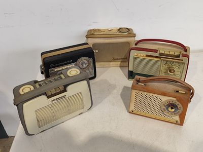 plusieurs modèles de radios posés sur une table blanche