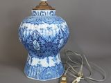 un vase bleu et blanc sur lequel est posée une lampe