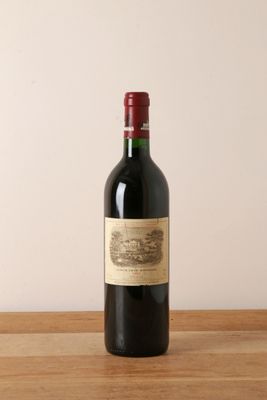 une bouteille de vin rouge posée sur une table en bois