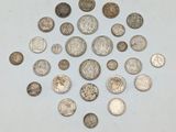 une pile de pièces d'argent posée sur une surface blanche