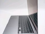 a silver laptop with a black keyboard on a white surface