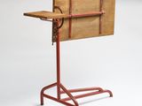 a small wooden table with a metal stand on it
