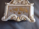a white and gold box with gold designs on it