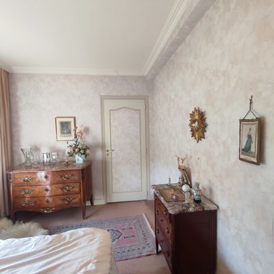 une chambre avec un lit, une commode, un miroir et un tapis
