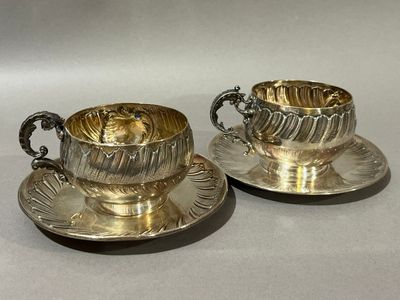 paire de tasses à thé et soucoupes en métal argenté, posées sur leurs soucoupes