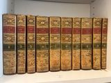 plusieurs vieux livres sont alignés sur une étagère dans une bibliothèque