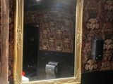 a bathroom with a sink, mirror, and toilet paper dispenser in it