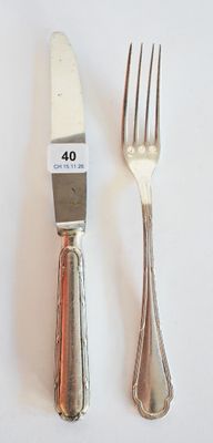 deux fourchettes et un couteau sur une table blanche