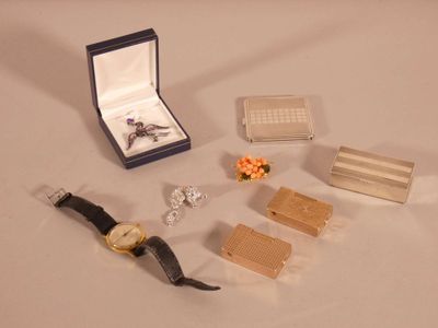 a watch, cufflinks, and other jewelry on a table