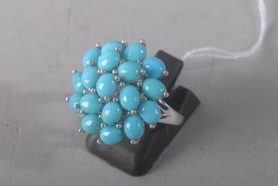 turquoise beaded ring with silver beads on a black block