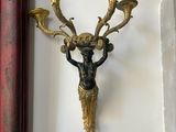 a picture of a clock on the wall next to a wall sconce