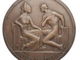 a close up of a bronze medal with a man and woman on it