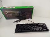 a black keyboard and a green box on a white table
