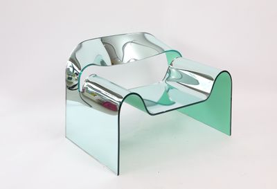 a glass chair that is sitting on a white surface