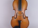 an old violin sitting on top of a white surface