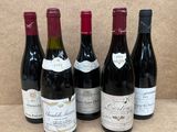 six bouteilles de vin rouge sont alignées sur une table