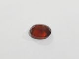 a red garnet stone on a white surface