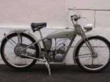 a silver motorcycle parked next to a white wall