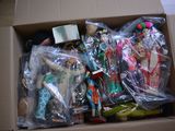 a cardboard box filled with dolls and other items