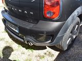a small black car parked on the side of the road