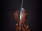 statue of a cello on a stand against a black background