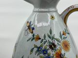a white vase with a floral design on it