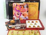 trois livres et une boîte de chocolats sont posés sur une table