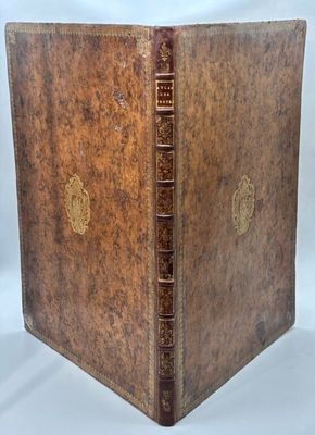 un livre ancien avec une couverture en cuir marron et des bordures dorées