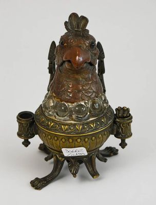 une image représentant un grand vase en bronze et de couleur bronze, orné d'un oiseau sur le col