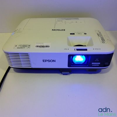 a white projector with a blue light on top of it