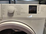 une image représentant une machine à laver avec une horloge sur la façade