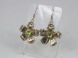 a close up of a pair of earrings with green stones