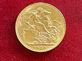 pièce d'or « sovereign » posée sur un tissu rouge, sur fond rouge