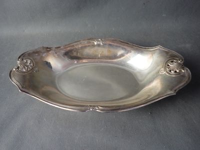 an antique silver plate on a table with a black background