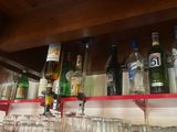 des bouteilles et des verres sont alignés sur une étagère dans un bar