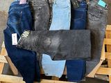 several pairs of jeans are stacked on a pallet in a warehouse