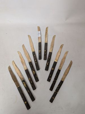six knives are lined up in a circle on a white surface