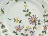 a white plate with yellow and purple flowers on it