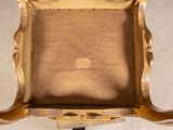 a gold chair with a brown seat on a white floor