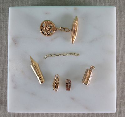 un plateau en marbre sur lequel sont disposés plusieurs bijoux en or