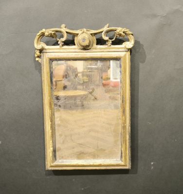 un miroir accroché au mur, avec une chaise à l'arrière-plan