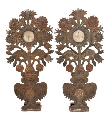 two ornate wooden sculptures with a clock on each of them